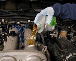 A Great Falls, MT service technician pouring fluid into a vehicle | Taylor's Auto Max
