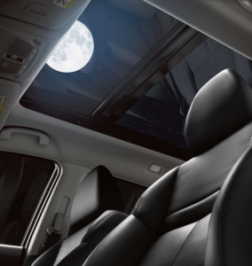 the moon seen trough the sunroof of a car